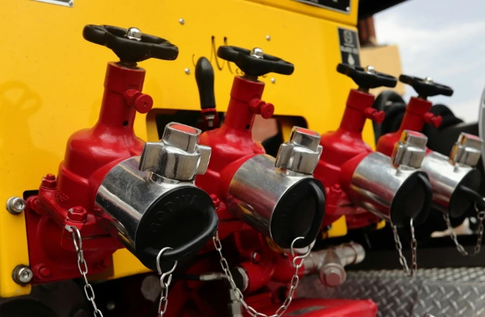 Red fire hydrant outlets with chains on yellow truck
